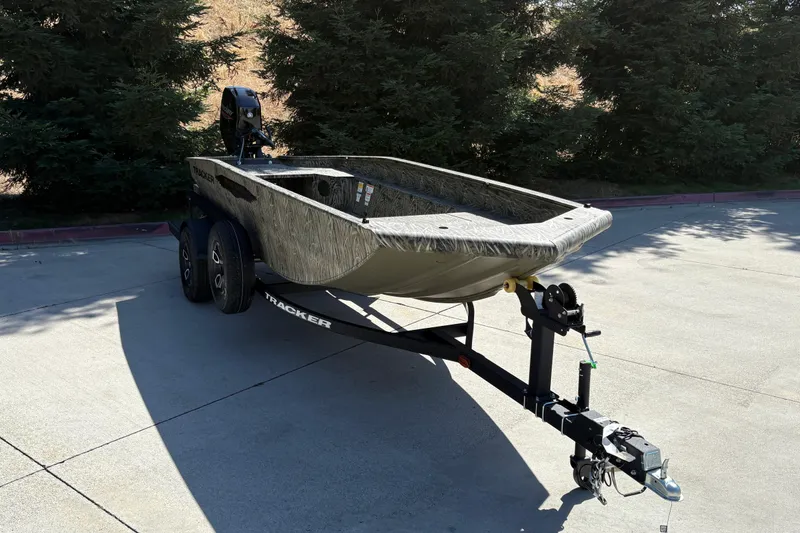 Slide: The Image of 2026 Tracker Grizzly 1650 T Prairie Wings Edition boat on trailer, parked outdoors. - 13