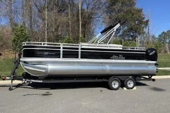 Slide: The Image of 2026 Sun Tracker Fishin' Barge 22 DLX pontoon boat on trailer, parked outdoors. - 71