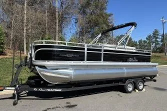 Slide: The Image of 2026 Sun Tracker Fishin' Barge 22 DLX pontoon boat on trailer, parked outdoors. - 72