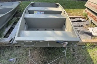 The Image of 2026 Tracker Grizzly 10 Jon boat on grass, showcasing interior seating and structure. - 0