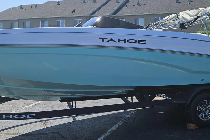 Slide: The Image of 2026 Tahoe T21 boat on trailer, light blue hull, parked outdoors. - 83