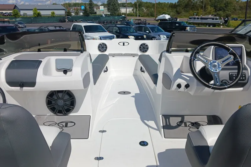 Slide: The Image of 2026 Tahoe T21 boat interior with modern dashboard and seating, parked outdoors. - 7