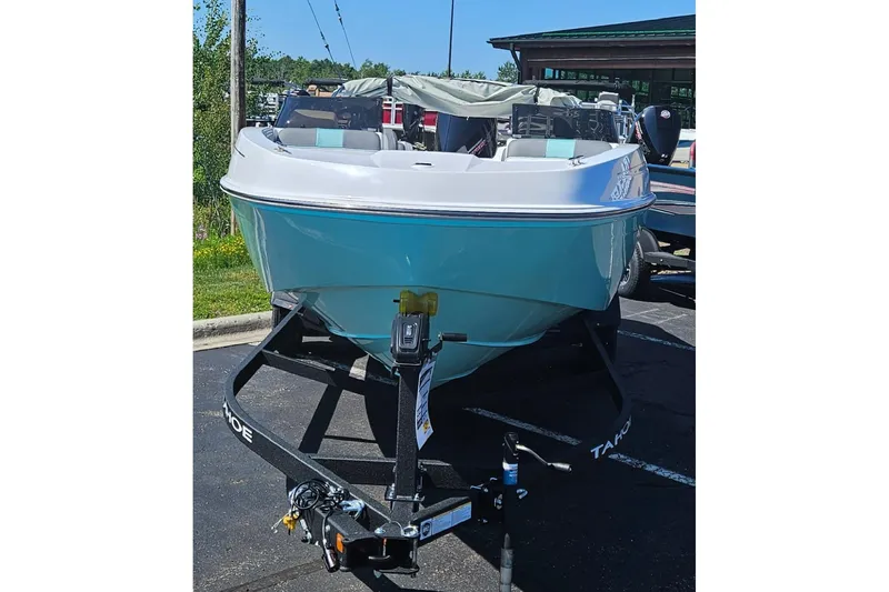 Slide: The Image of 2026 Tahoe T21 boat on trailer, parked outdoors, showcasing sleek design and modern features. - 84