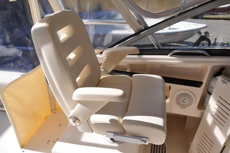 Slide: The Image of Captain's chair in 2015 Grady-White Marlin 300 boat cockpit, featuring beige upholstery. - 16