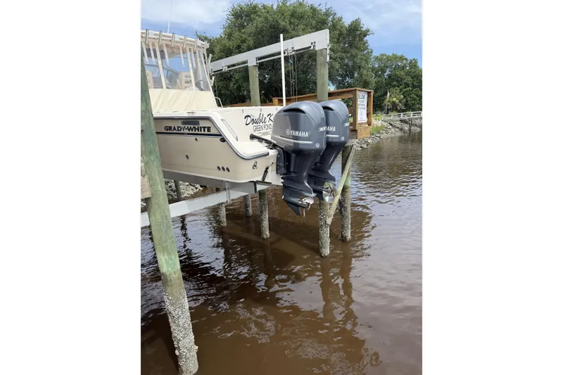 Slide: The Image of 2015 Grady-White Marlin 300 boat on trailer with Yamaha engines, parked outdoors. - 2