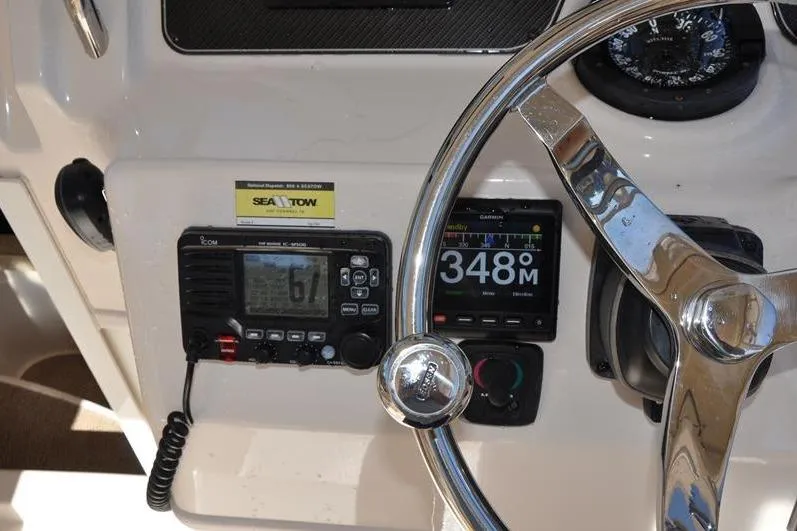 Slide: The Image of 2015 Grady-White Marlin 300 dashboard with steering wheel and navigation instruments. - 20