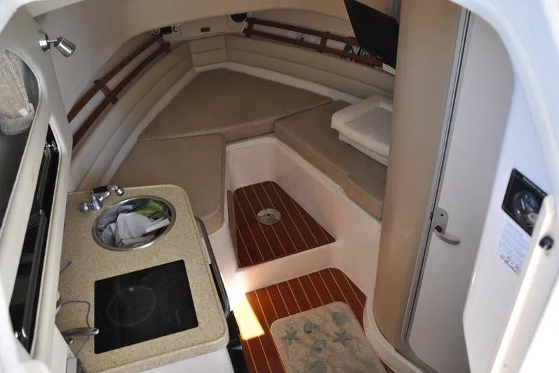 Slide: The Image of 2015 Grady-White Marlin 300 cabin interior with kitchenette and seating area. - 24