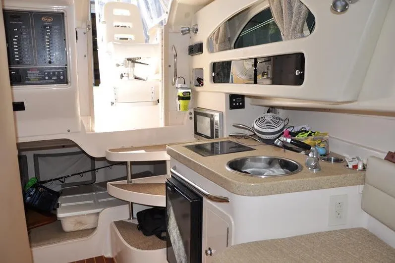 Slide: The Image of Interior of 2015 Grady-White Marlin 300 boat with kitchenette and seating area. - 25