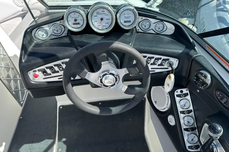 Slide: The Image of Dashboard of a 2007 MasterCraft X-15 boat with gauges and steering wheel. - 6