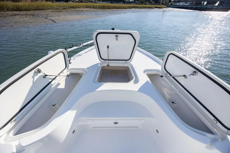 Slide: The Image of 2019 Sea Hunt BX 22 BR boat with open storage compartments on calm water. - 10