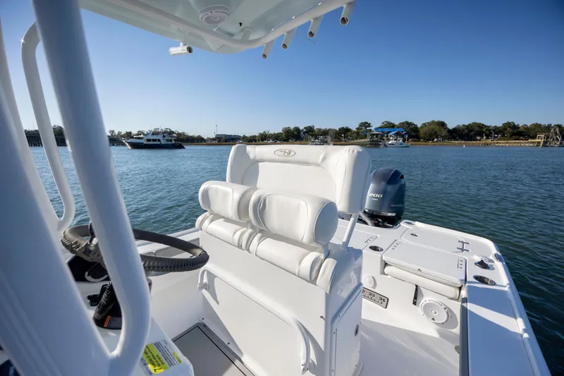 Slide: The Image of 2019 Sea Hunt BX 22 BR boat interior with steering wheel and seating, on calm water. - 16