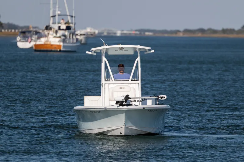 Slide: The Image of 2019 Sea Hunt BX 22 BR boat cruising on calm waters with other boats in the background. - 8