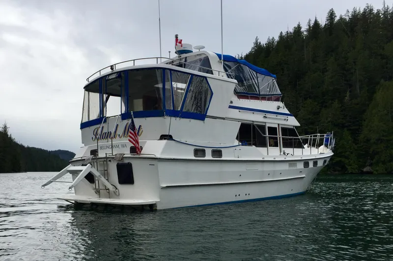 Slide: The Image of 1986 CHB Ponderosa yacht on serene water, surrounded by lush forest. - 0
