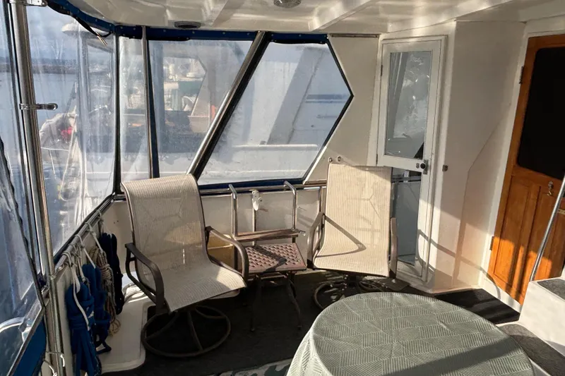 Slide: The Image of Enclosed deck area of a 1986 Ponderosa boat with chairs and table. - 10