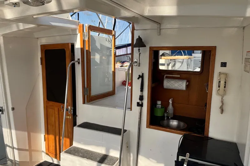 Slide: The Image of Interior of a 1986 Ponderosa boat with wooden doors and compact kitchen area. - 11