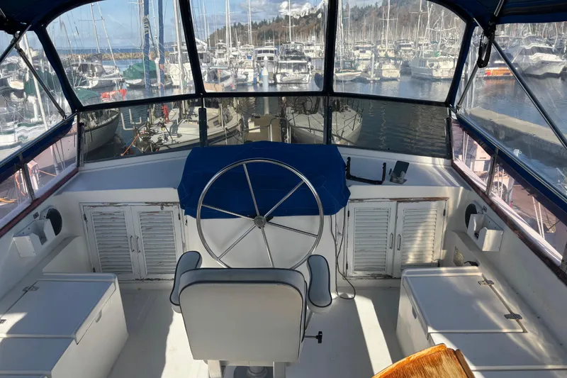 Slide: The Image of Helm of 1986 Ponderosa boat with marina view, featuring steering wheel and seating. - 12