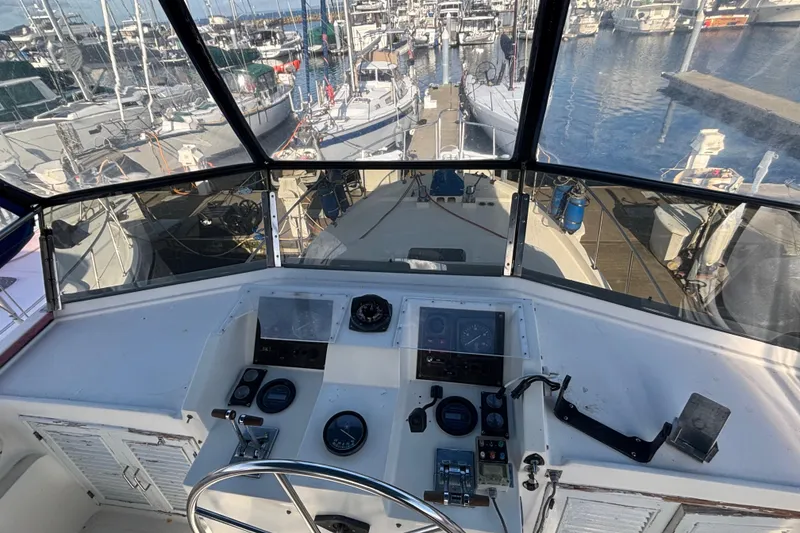 Slide: The Image of Helm of 1986 Ponderosa boat overlooking marina with docked sailboats. - 13