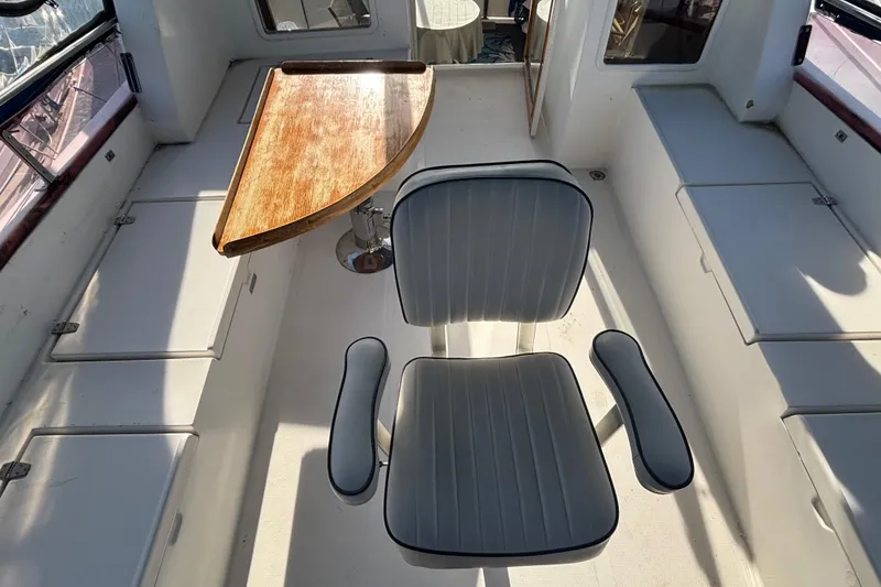 Slide: The Image of Interior of a 1986 Ponderosa boat with a chair and wooden table. - 14