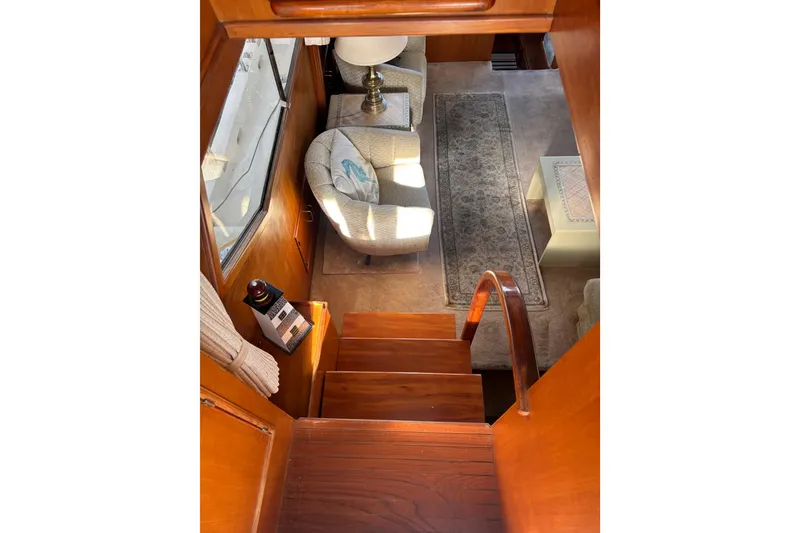 Slide: The Image of Interior of a 1986 Ponderosa boat with wooden stairs and cozy seating area. - 18