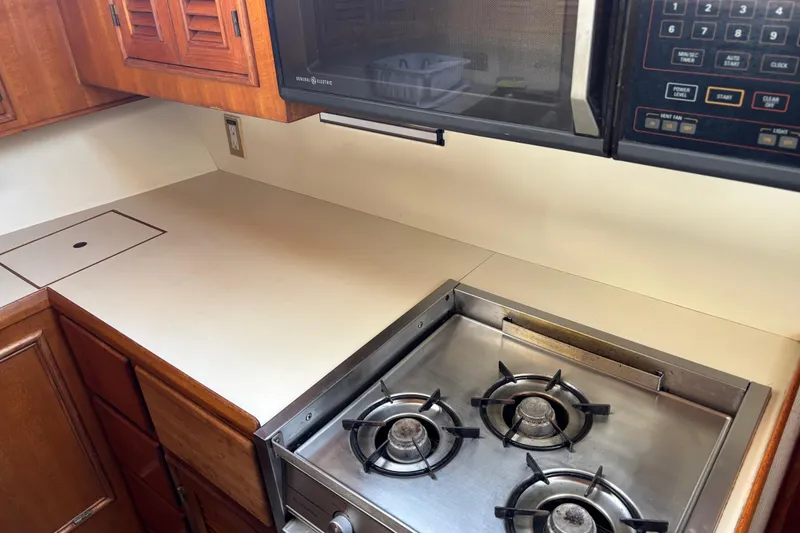 Slide: The Image of 1986 Ponderosa kitchen with gas stove, microwave, and wooden cabinets. - 34