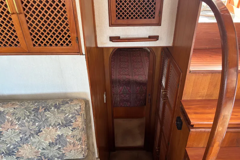 Slide: The Image of 1986 Ponderosa boat interior with wooden cabinetry, floral upholstery, and carpeted hallway. - 37