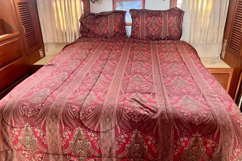 Slide: The Image of Luxurious bedroom interior of 1986 CHB Ponderosa with elegant red patterned bedding. - 38