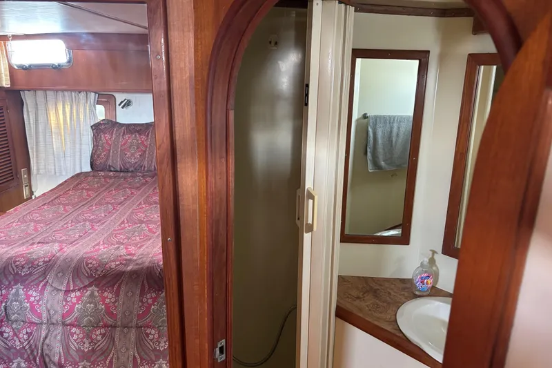 Slide: The Image of Cozy 1986 Ponderosa boat interior with bedroom and bathroom, featuring wood accents and patterned bedding. - 40