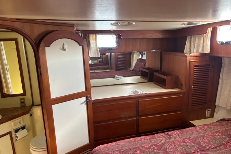 Slide: The Image of 1986 Ponderosa boat interior with wooden cabinetry, bed, and bathroom door. - 41