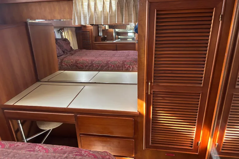 Slide: The Image of 1986 Ponderosa interior with wooden cabinetry, mirrored vanity, and patterned bedding. - 42