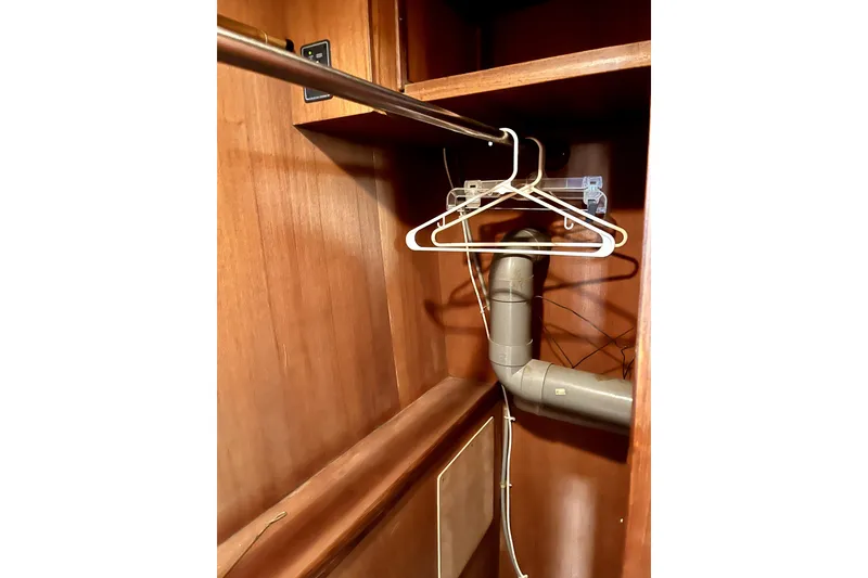Slide: The Image of Wooden closet interior with hangers and visible piping, CHB Ponderosa 1986 model. - 48