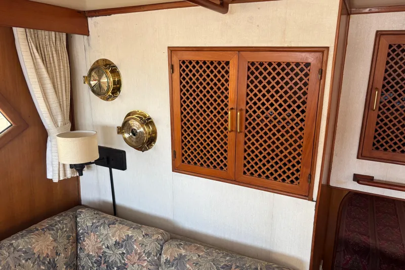 Slide: The Image of 1986 Ponderosa interior with wooden lattice cabinets, brass fixtures, and floral-patterned sofa. - 49