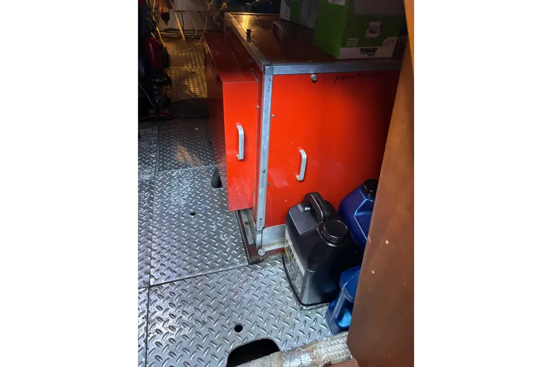 Slide: The Image of Red storage cabinet in 1986 Ponderosa vehicle interior with metal flooring and containers. - 50