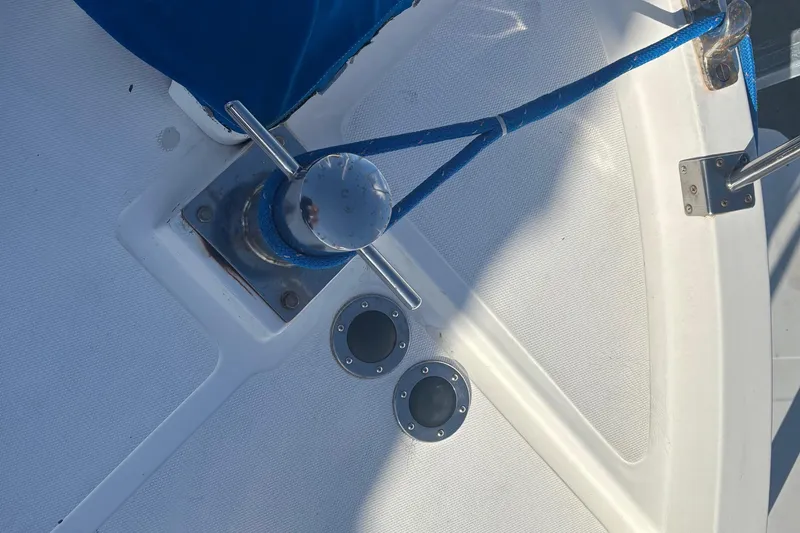 Slide: The Image of 1986 Ponderosa boat deck with cleat, blue cover, and rope. - 8