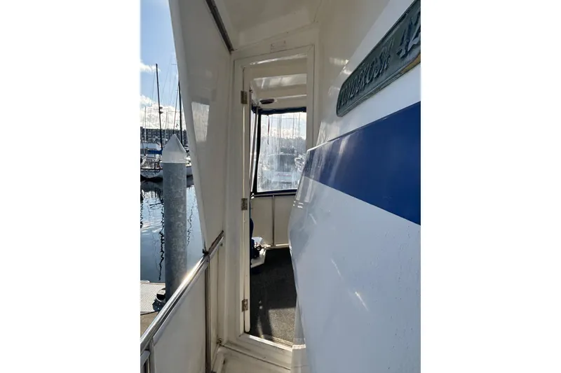 Slide: The Image of 1986 Ponderosa boat entrance with blue stripe, docked at marina. - 9