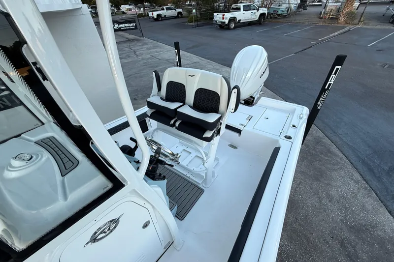 Slide: The Image of 2026 Tidewater 2300 Carolina Bay boat top with rod holders and speakers, under clear sky. - 4