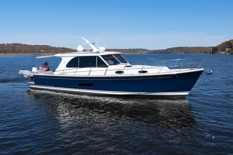The Image of 2019 Grand Banks 44 Eastbay SX yacht cruising on a calm lake under clear skies. - 0