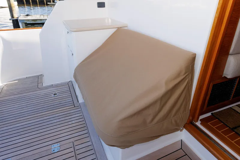 Slide: The Image of 2019 Grand Banks 44 Eastbay SX deck with covered equipment and wooden flooring. - 12
