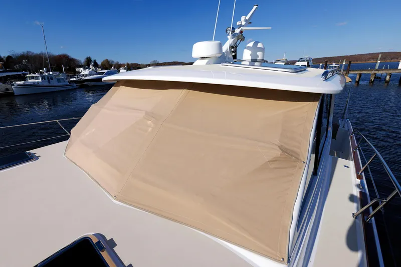 Slide: The Image of 2019 Grand Banks 44 Eastbay SX yacht with beige sunshade, docked in a marina. - 13