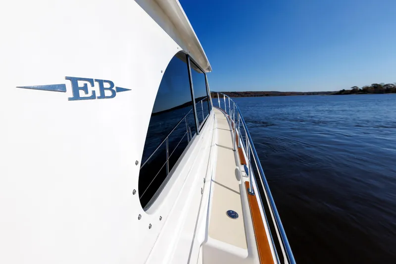 Slide: The Image of 2019 Grand Banks 44 Eastbay SX yacht cruising on calm waters under clear blue sky. - 15