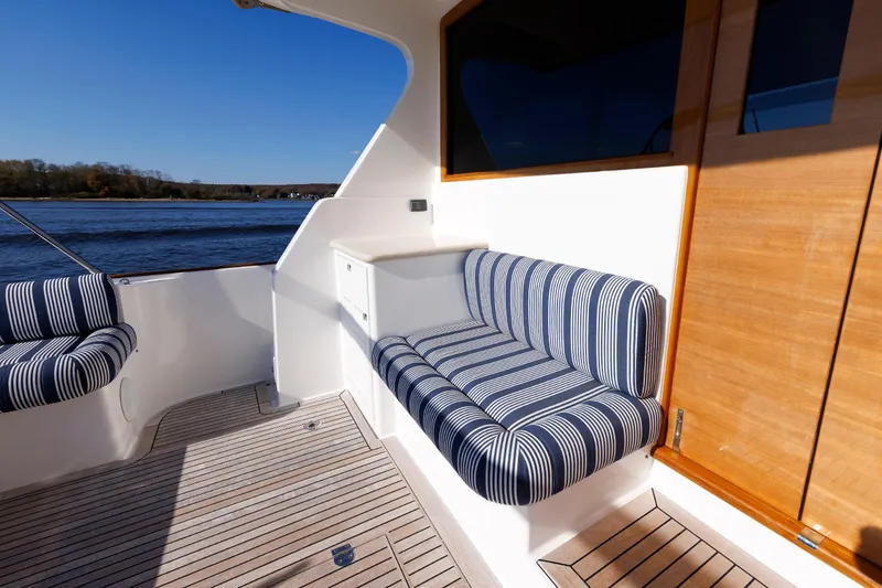 Slide: The Image of 2019 Grand Banks 44 Eastbay SX yacht with striped seating and wooden deck. - 27