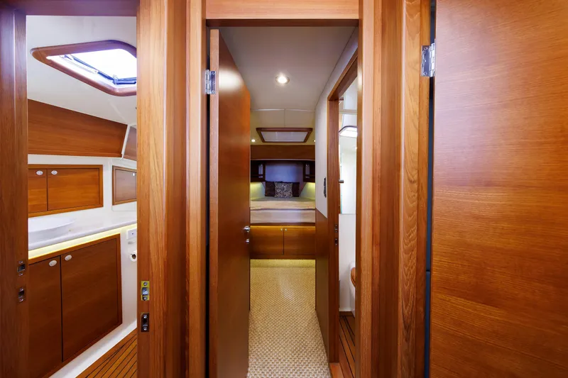 Slide: The Image of 2019 Grand Banks 44 Eastbay SX interior with wooden cabinetry and cozy bedroom. - 41