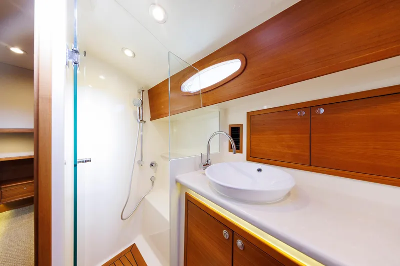 Slide: The Image of Luxurious bathroom in 2019 Grand Banks 44 Eastbay SX yacht with modern fixtures and wood accents. - 46
