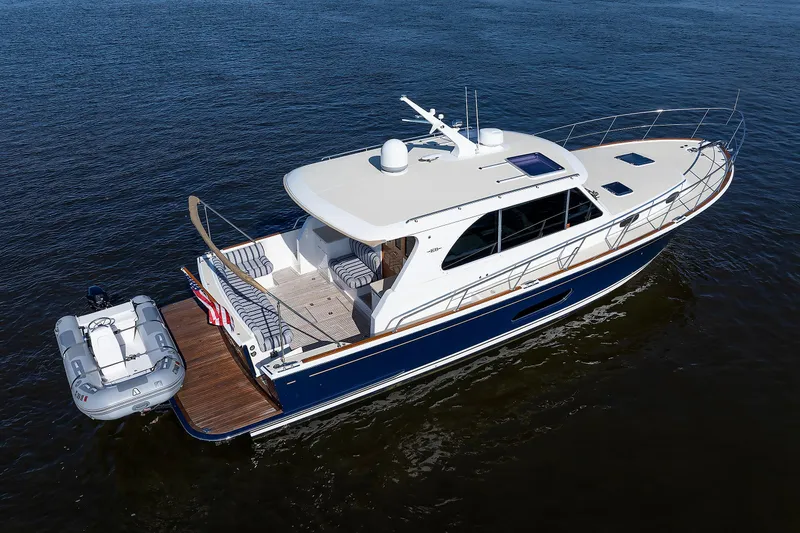 Slide: The Image of 2019 Grand Banks 44 Eastbay SX yacht on calm water, featuring sleek design and spacious deck. - 5