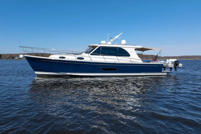 Slide: The Image of 2019 Grand Banks 44 Eastbay SX yacht on calm water under clear blue sky. - 6
