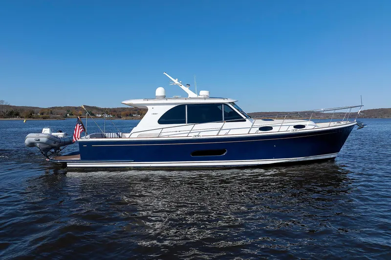 Slide: The Image of 2019 Grand Banks 44 Eastbay SX yacht on calm water under clear blue sky. - 63