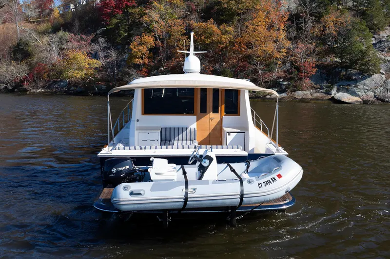Slide: The Image of 2019 Grand Banks 44 Eastbay SX yacht with dinghy on scenic river. - 9