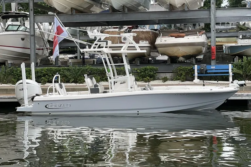 Slide: The Image of 2022 Robalo 246 Cayman SD boat docked, featuring sleek design and Yamaha engine. - 23