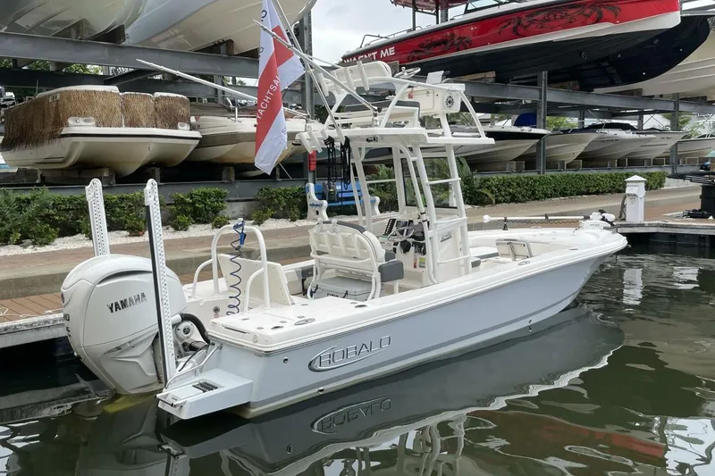 Slide: The Image of 2022 Robalo 246 Cayman SD boat docked, featuring Yamaha engine and sleek design. - 25