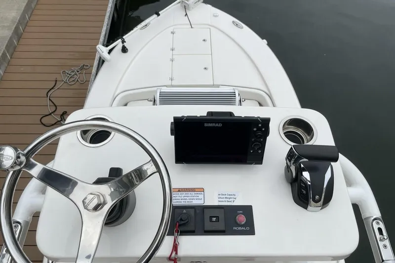 Slide: The Image of 2022 Robalo 246 Cayman SD boat dashboard with steering wheel and navigation system. - 28