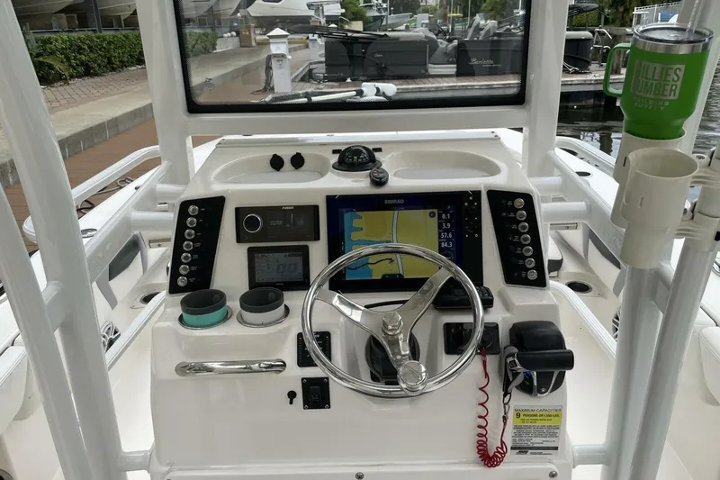 Slide: The Image of 2022 Robalo 246 Cayman SD boat dashboard with navigation controls and steering wheel. - 29